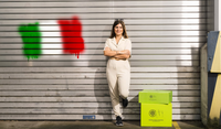 A Kukko employee leans against a roller shutter with an Italian flag